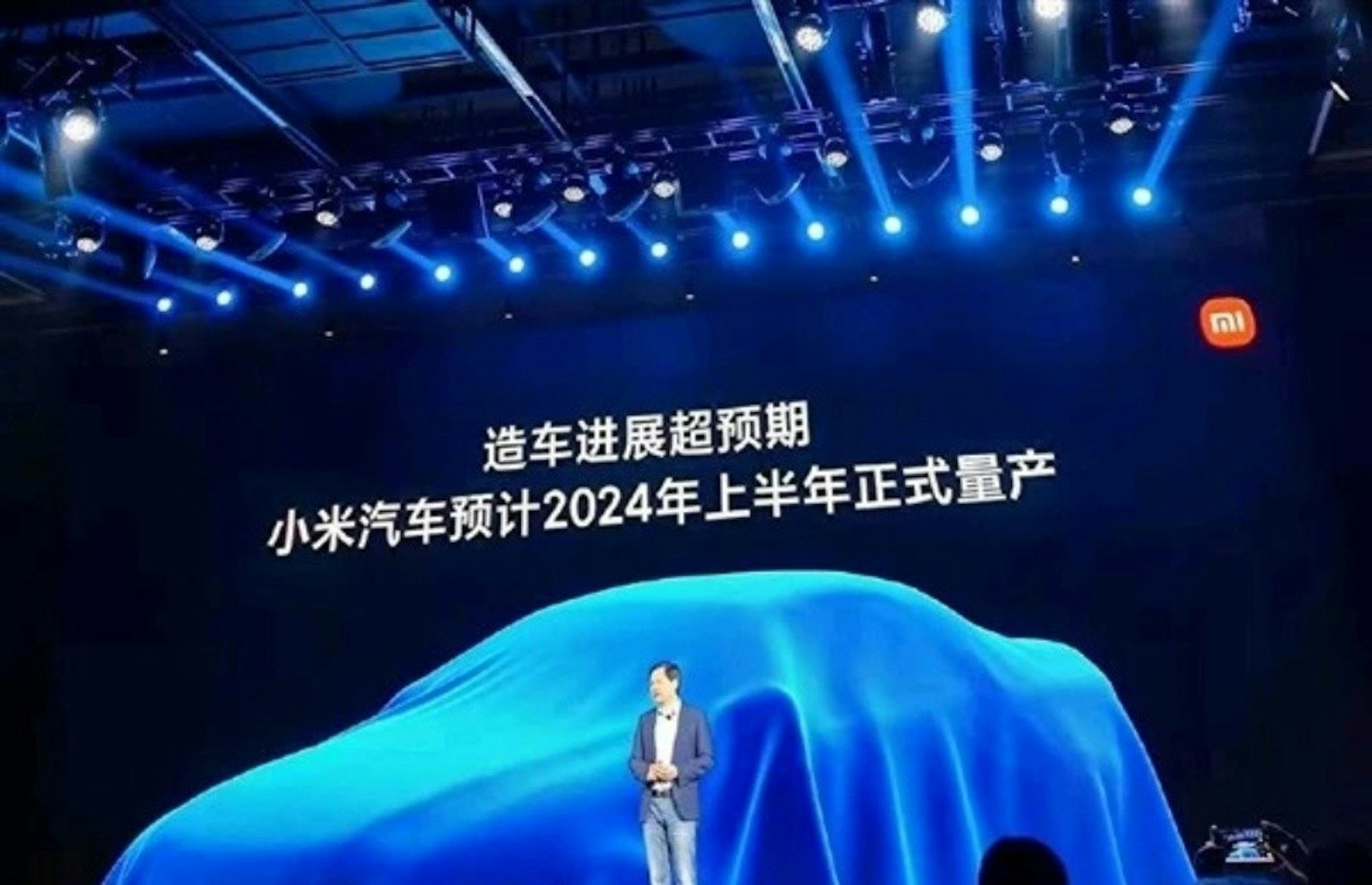 照片中提到了MI、造车进展超预期、小米汽车预计2024年上半年正式式量产，包含了川崎、搖滾音樂會、牆紙、音樂會、顯示裝置