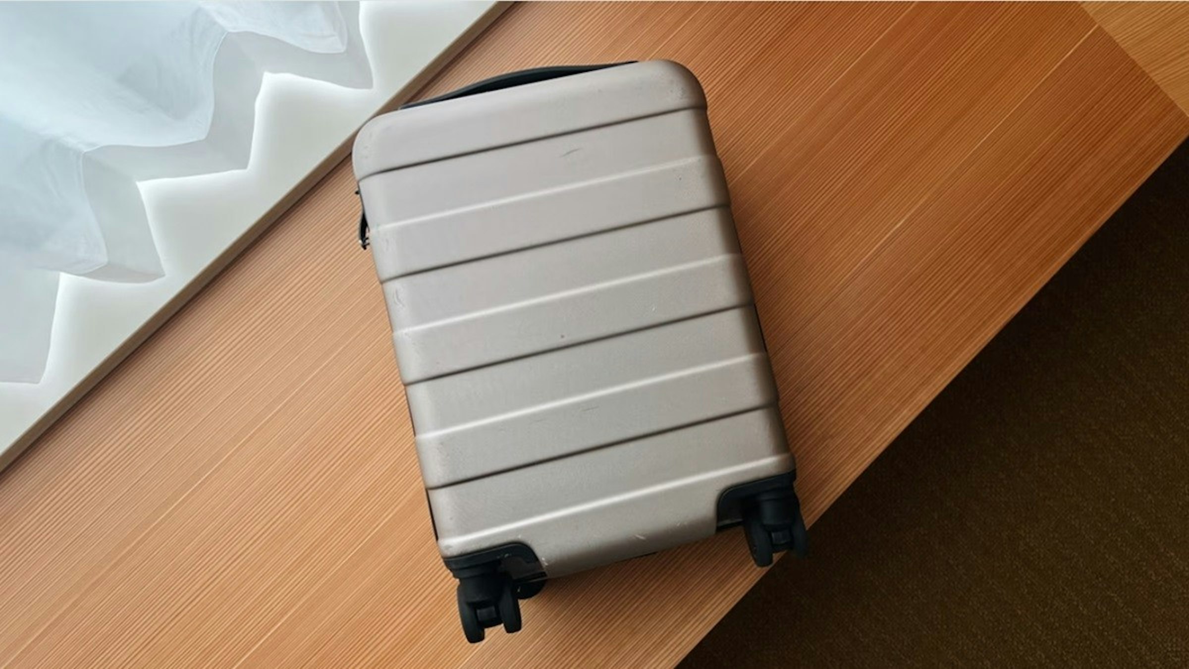 照片中包含了地板、無印良品、MUJI 可調式手把硬殼行李箱 36L、手提箱、MUJI 硬式手提箱，附可調整高度的手提桿