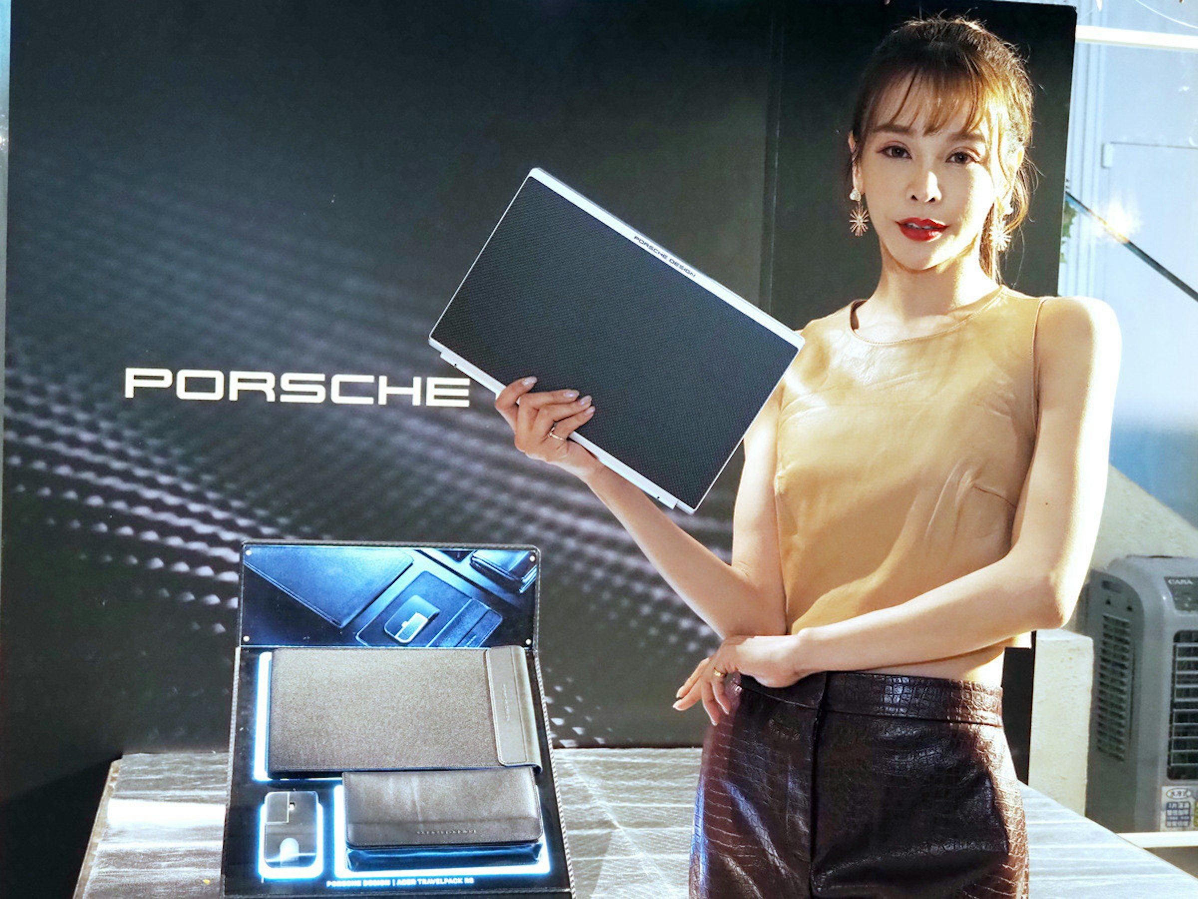 照片中提到了PORSC HE、POO DO 1 TRAVELMOK，跟保時捷有關，包含了肩、顯示裝置、電子產品、電子視覺顯示