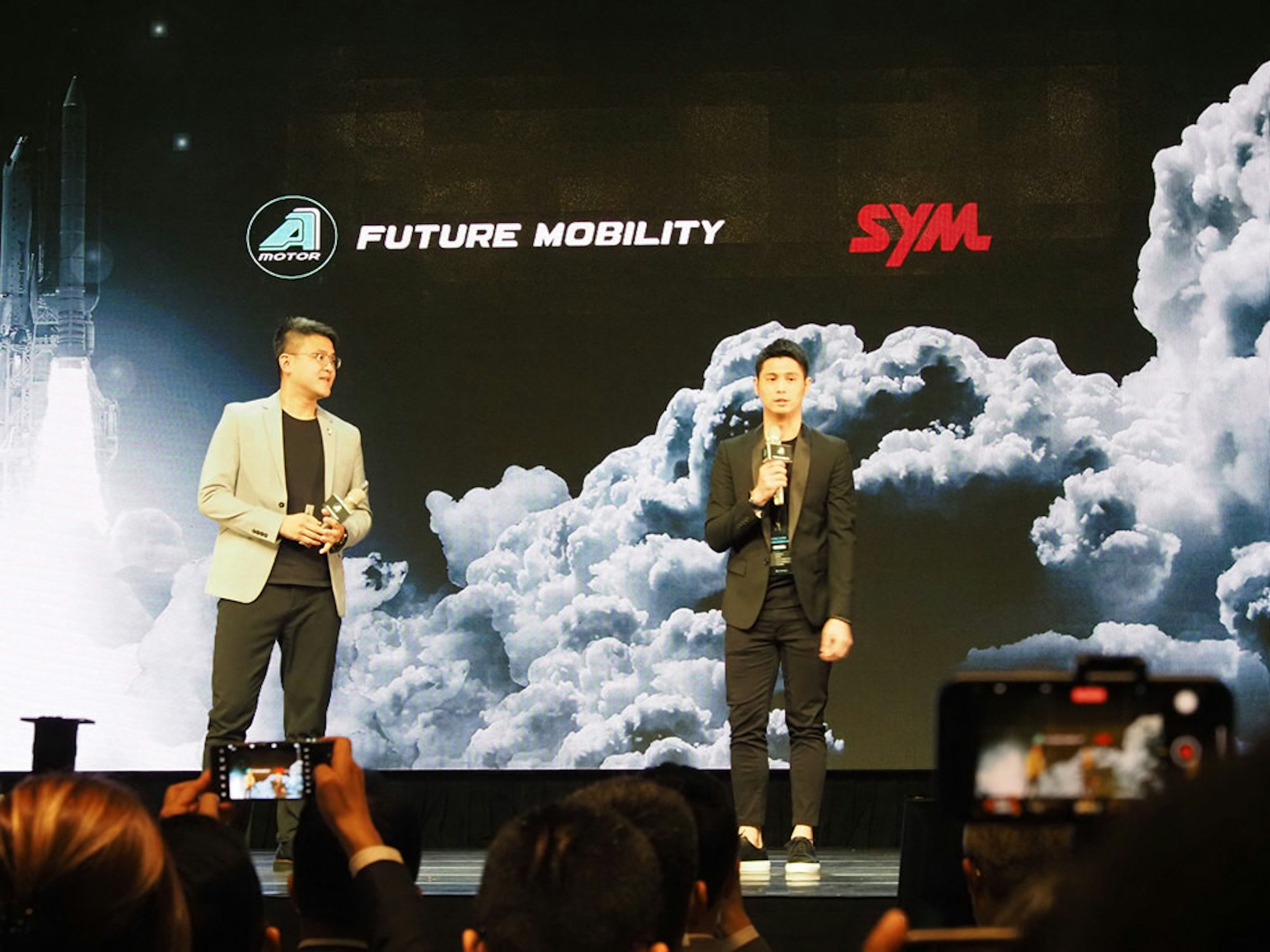 照片中提到了SYM、FUTURE MOBILITY、MOTOR，跟SYM汽車、阿達克斯石油有關，包含了階段、羅尼·多斯（Ronnie Doss）、音樂會、領導、劇院