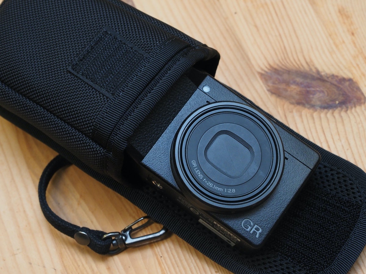 照片中提到了amia、GR LENS f=26.1mm 1:2.8、GR,包含了背帶、鏡頭、數碼相機、相機、鏡片