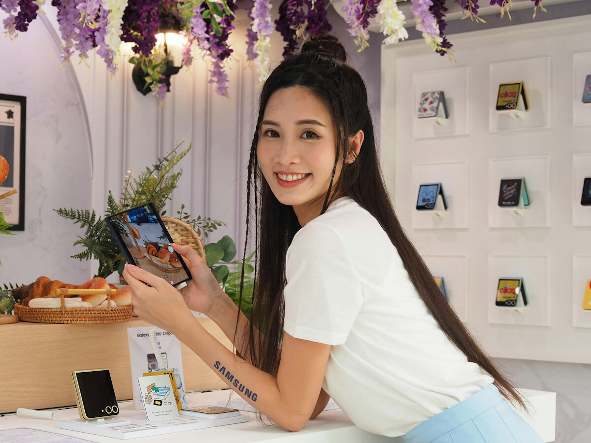 照片中提到了Galaxy、ids Z Flip、100，跟三星有關，包含了女孩、花、人造植物、蘭花花