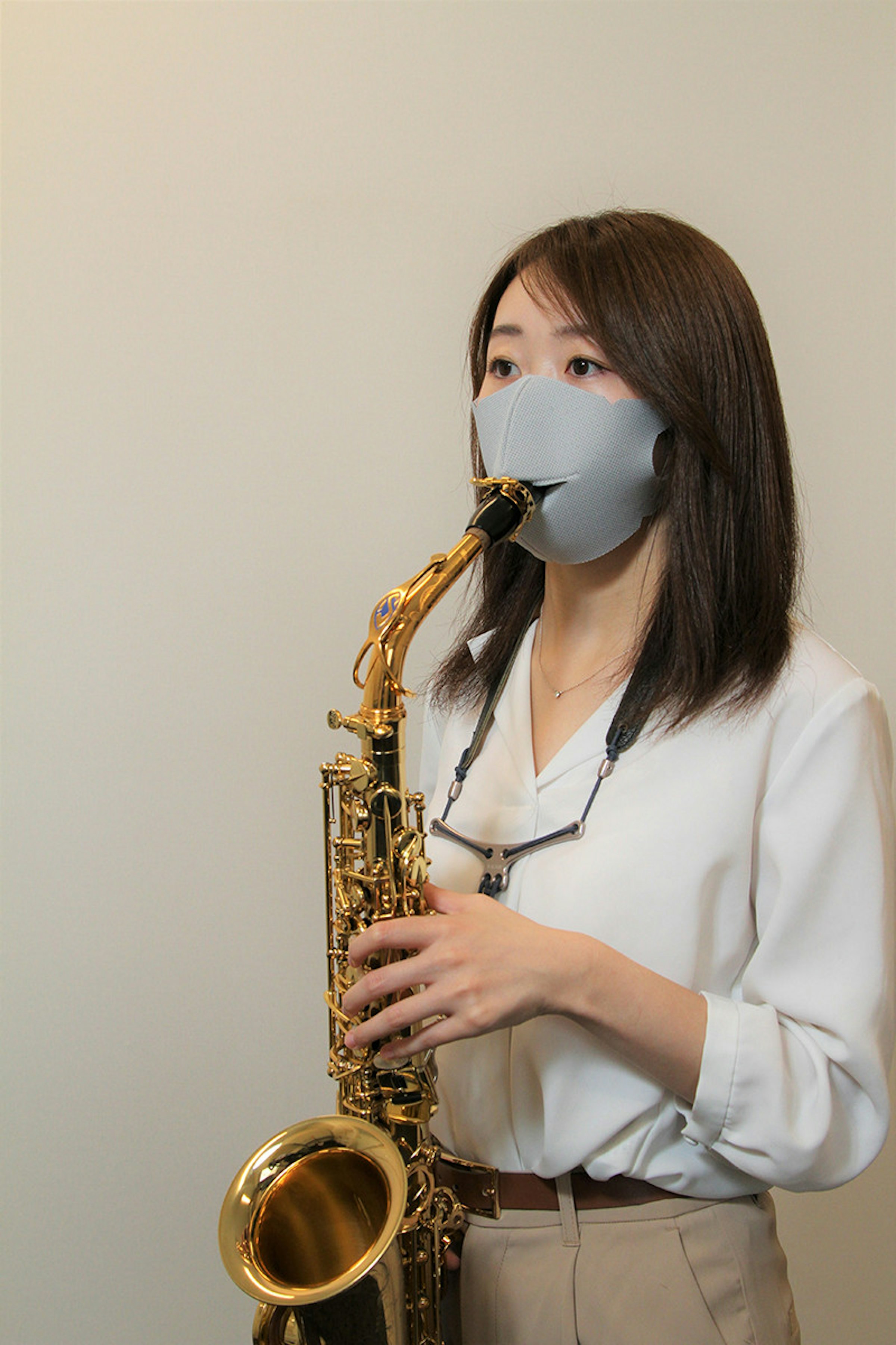照片中包含了薩克斯演奏家、中音薩克斯風、薩克斯風、面具、管樂器