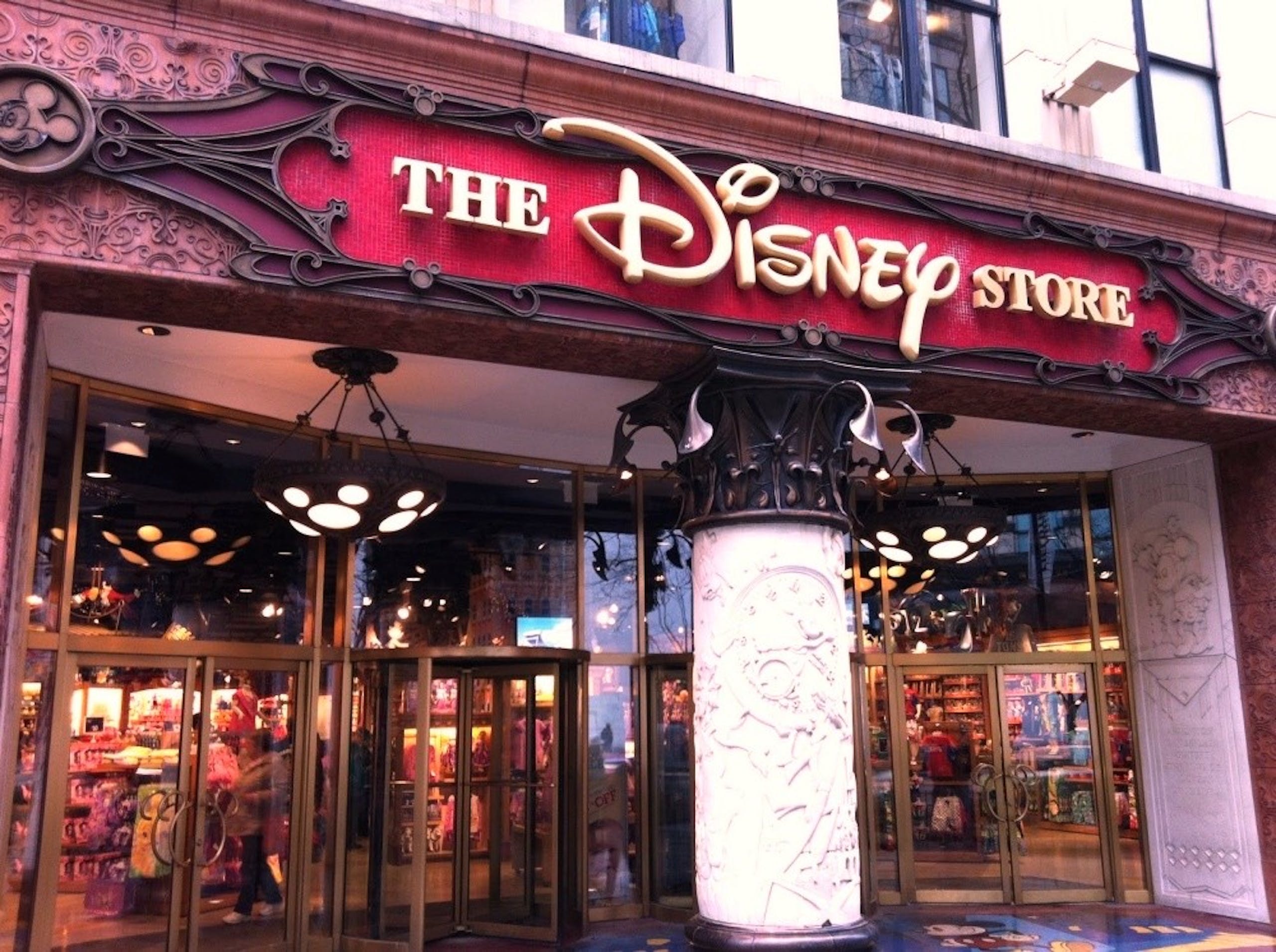 照片中提到了THE、DISNEY、STORE，跟華特迪士尼世界有關，包含了芝加哥迪士尼商店、shop迪士尼、沃爾特迪斯尼公司、玩具店、迪士尼商店